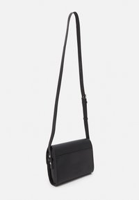 Černá kožená crossbody taška s obdélníkovým tvarem, nastavitelným popruhem a minimalistickým designem. Vyznačuje se hladkým povrchem a jemnými kovovými akcenty.