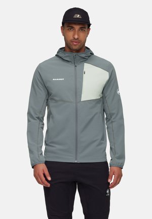 Lichtgrijze ritsjack met een contrasterend lichtgroen borstpaneel, gemaakt van gestructureerde stof, met een capuchon en zijzakken.