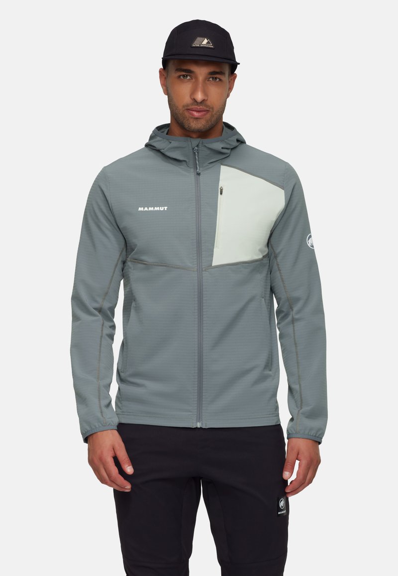 Lys grå zip-up jakke med en kontrasterende bleg grøn brystpanel, lavet af tekstureret stof, med hætte og sidelommer.