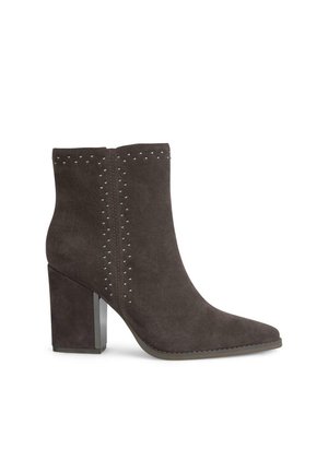 Botas de ante gris oscuro hasta el tobillo con punta afilada, adornadas con tachuelas plateadas en los costados y un tacón grueso con un acabado brillante.