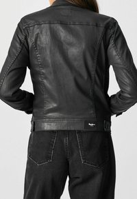 Schwarze Lederjacke mit glatter Textur, klassischem Kragen und sichtbaren Nähten. Verfügt über ein Markenschild auf der Rückseite und eine taillierte Passform.