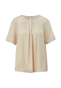 Blouse à manches courtes en tissu beige doux, présentant un col rond, un devant plissé et un dos avec une ouverture en forme de goutte d'eau fermée par un bouton.