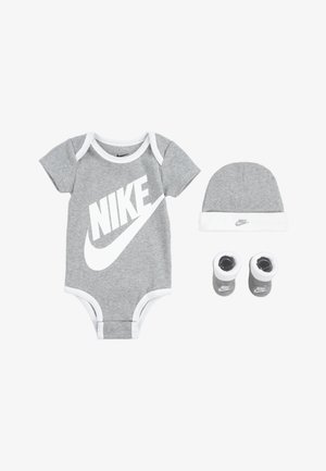 Combinaison en coton gris avec des accents blancs, mettant en avant un grand logo Nike blanc, assortie d'un bonnet et de chaussons, tous deux avec le logo.