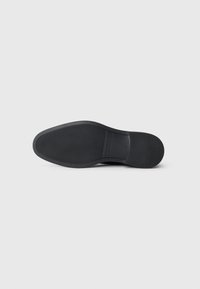 Schwarze Schuhsohle mit strukturiertem Grip, rechteckigem Logo-Bereich in der Mitte und der Größenangabe 41 nahe der Ferse.