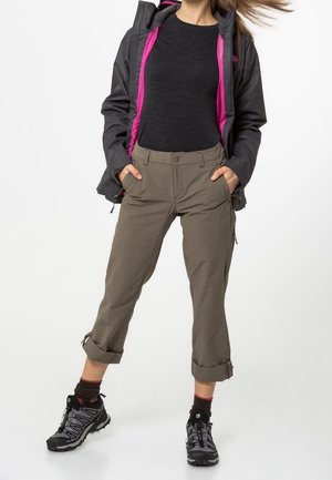 Utomhusoutfit med en grå jacka med rosa foder, svart topp, khaki capribyxor och svarta vandringsskor med ankelsockor.