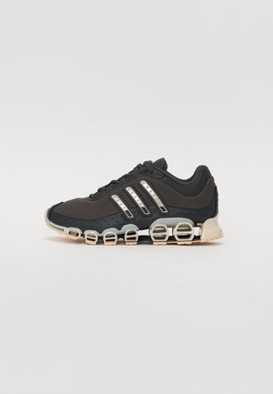Black and gray athletic shoe with a spring-like segmented sole and three metallic striped details on the side.
