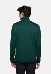 Pullover verde scuro a maniche lunghe con colletto alto, caratterizzato da un tessuto testurizzato e pannelli laterali a contrasto. Include una finitura ordinata senza accessori.