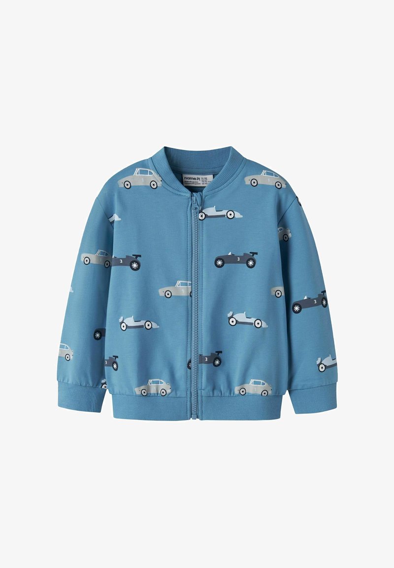 Veste zippée bleu pour enfants avec des motifs vintage et de voitures de course en gris et noir imprimés partout.