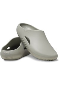 Zoccoli Crocs di colore grigio chiaro, realizzati in materiale simile alla gomma, con punta chiusa, tallone aperto e fori di ventilazione laterali. Suola testurizzata e rigata.