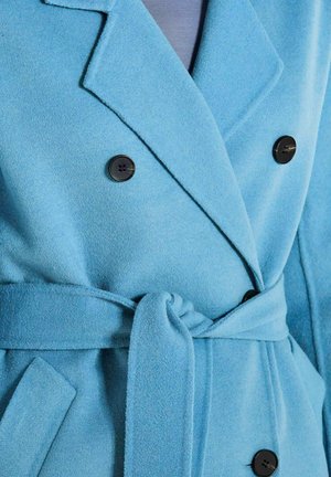 Blauer Wollmantel mit schwarzen Knöpfen, breiten Revers, Fronttaschen und einem gebundenen Stoffgürtel um die Taille.