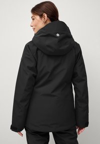 Zwarte waterdichte jas met capuchon, met een gladde textuur, verstelbare manchetten en een klein geborduurd logo op de achterkant.