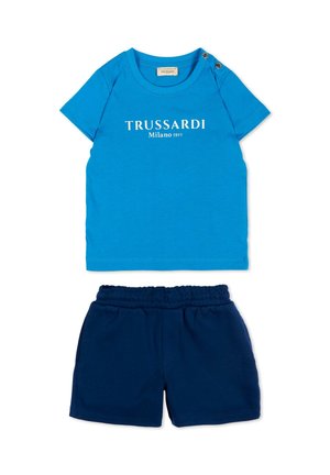 T-shirt blu a maniche corte Trussardi Milano 1911 con due bottoni sulle spalle abbinata a pantaloncini blu scuro con vita elasticizzata.