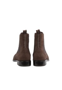 Brown suede ankle boots with elastic side panels, decorative brogue detailing, and dark rubber soles. Features pull tabs for easy wear.