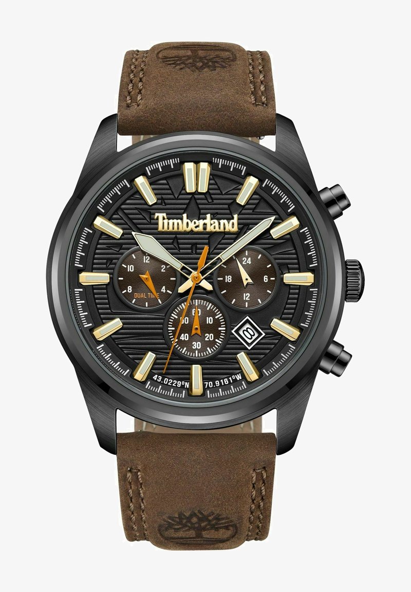Ruskea nahkarannekello, jossa on musta teksturoitu kellotaulu. Varustettu kultasävyisillä ja oransseilla yksityiskohdilla, chronograph-alaluvuilla ja päivämääränäytöllä.