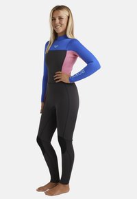 Neoprenový oblek s modrým, růžovým a černým vzorem. Vyrobený z pružného, strukturovaného neoprenu s zesílenými kolenními chrániči a vysokým výstřihem.