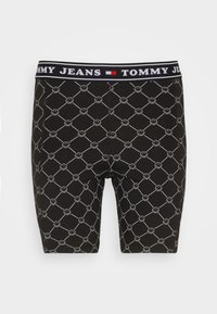 Shorts boxer neri con un motivo ripetuto di faccine bianche in un design geometrico. Elastico con l'etichetta "TOMMY JEANS."