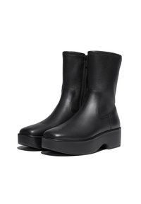 Zwarte leren enkellaarzen met een gladde textuur, zijrits en een stevige platformzool. Minimalistisch ontwerp en een ronde neus.