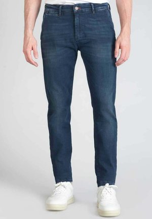Jeans in denim blu scuro con una vestibilità slim. Presentano un classico stile a cinque tasche, leggere sfumature e una chiusura con bottone frontale.