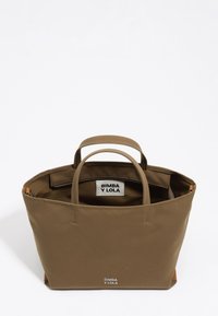 Brązowa torba typu tote Bimba y Lola z dwoma rączkami, otwarta góra ukazująca wewnętrzną metkę i kieszeń na zamek, na białym tle.