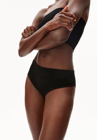 Zwarte geribbelde hoge taille onderbroek met een brede elastische tailleband. Glad oppervlak, naadloos ontwerp en aansluitende pasvorm.