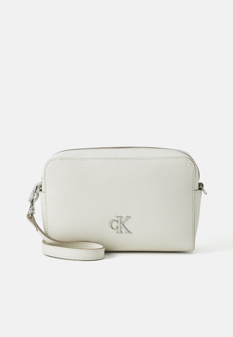White textured faux leather crossbody bag with a zip closure, adjustable strap, and a silver CK logo on the front. Compact rectangular shape.