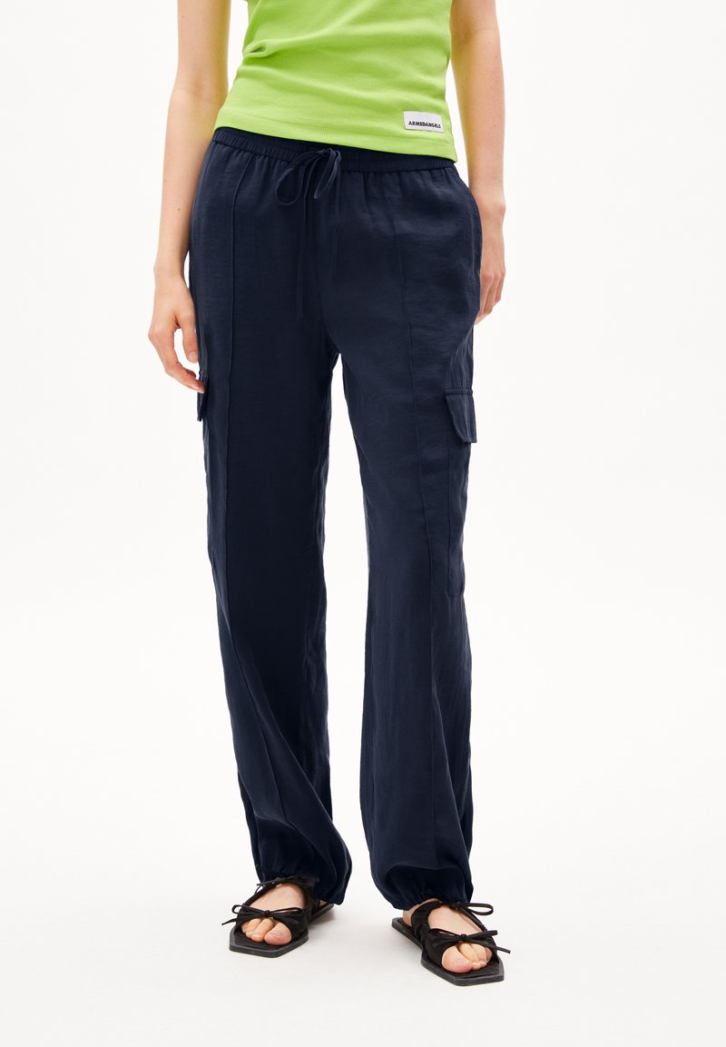 Pantalons légers bleu marine avec une taille élastique, cordon de serrage ajustable et poches cargo latérales ; texture lisse avec une coupe décontractée.