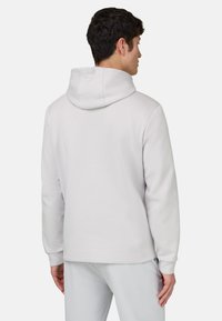 Sweat à capuche gris clair en tissu doux, doté d'une capuche avec cordon de serrage et de poignets côtelés. Le design est simple, sans logo ni motif visible.
