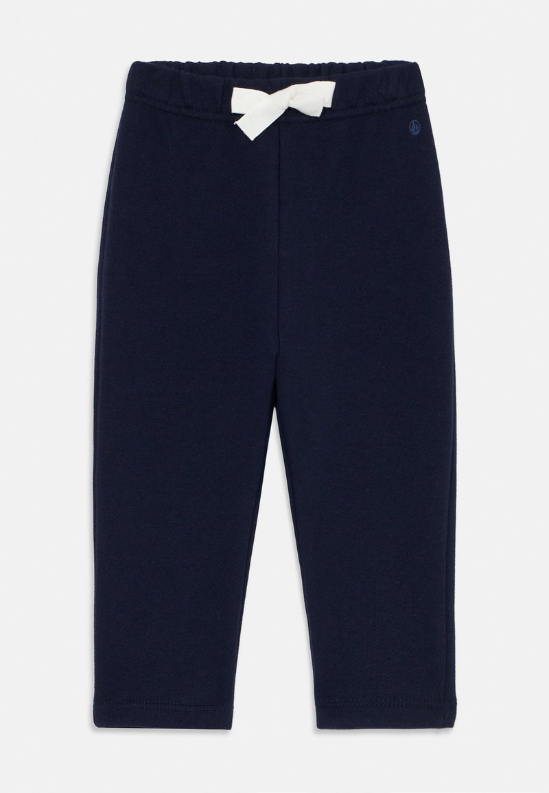 Gaiši zilas bērnu bikses ar elastīgu jostu un baltu tauriņu priekšā, izgatavotas no mīkstas auduma.