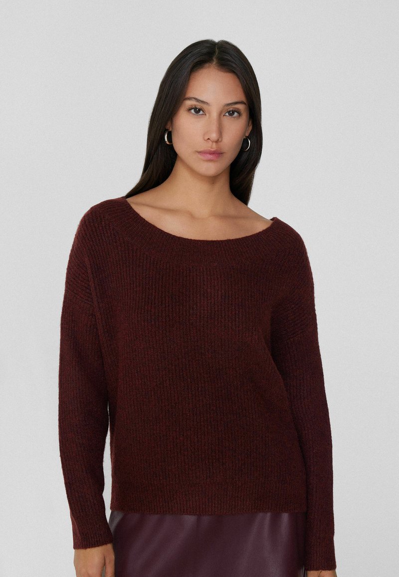 Jersey de punto burdeos con un escote amplio, textura acanalada y mangas largas, con un corte holgado y tejido suave.