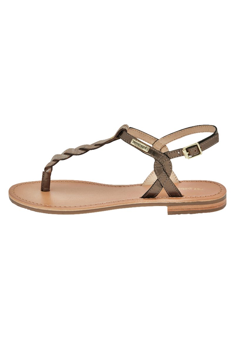 Sandal in pelle marrone con una fascia intrecciata sulla punta, cinturino alla caviglia regolabile, suola piatta e design minimalista.