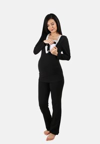 Conjunto de ropa de maternidad en negro, que incluye una blusa con encaje en el escote y pantalones cómodos, diseñado para un fácil acceso.