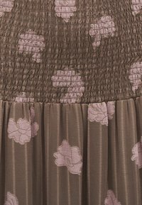 Robe en tissu marron avec un corsage froncé. Présente une broderie florale rose clair et des rayures verticales sur la partie jupe. Texture légère.