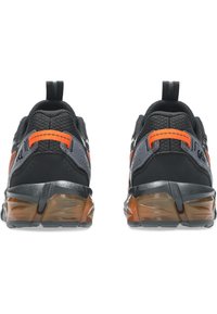 Scarpe sportive nere e grigie con un accento arancione. Tomaia in mesh e materiale sintetico, suola in gomma con una finitura testurizzata, dotate di una linguetta per il calzo.