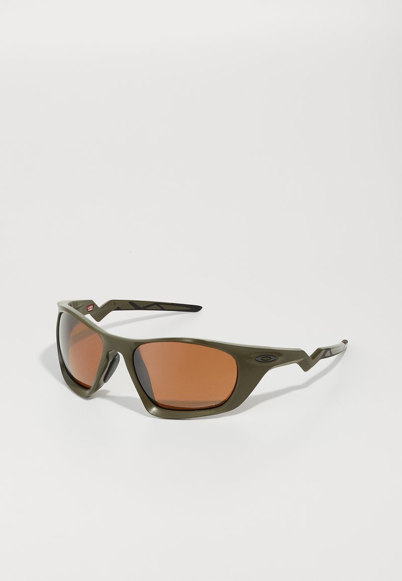 Olivgrüne Sonnenbrille mit rechteckigen Gläsern und orangefarbiger Tönung, mit einem strukturierten Rahmen und markanten, eckigen Bügeln.