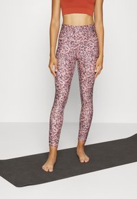 Leggings rosa e viola con motivo, realizzati in tessuto elasticizzato, con vita alta e texture liscia, abbinati a un crop top con texture.