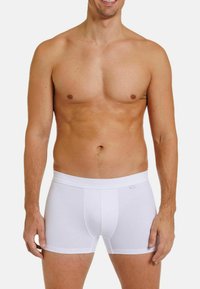 White cotton boxer briefs with a soft elastic waistband. The fabric is smooth and fitted, offering a classic and simple design.
