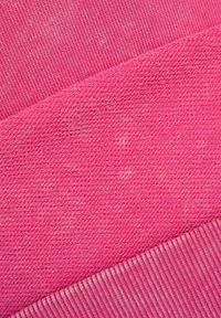 Tkanina polarowa w intensywnym różowym kolorze o różnych teksturach; posiada prążkowane mankiety i lekko melanżowy wygląd. Idealna na codzienne ubrania.