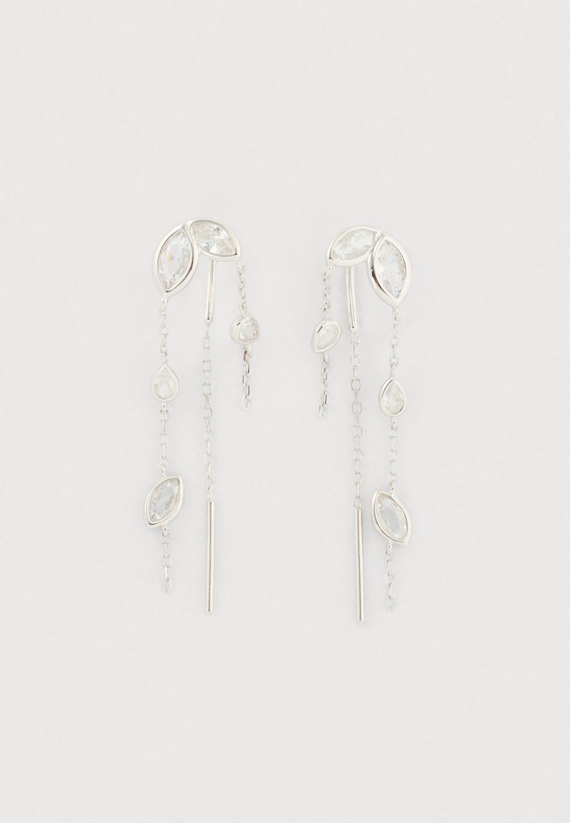 Brincos em tom prateado com pedras transparentes em formato de marquise e gota, e finesse de correntes penduradas em comprimentos variados sobre um fundo branco.