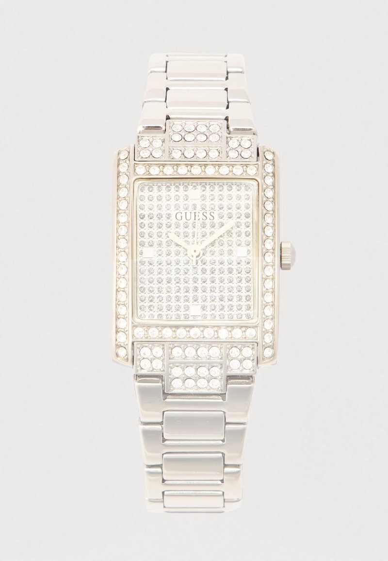 Sudraba taisnstūra pulkstenis ar kristāliem rotātu rāmīti, strukturētu ciparnīcu un metāla saišu aproci. Zīmola logotips redzams pulksteņa centrā.