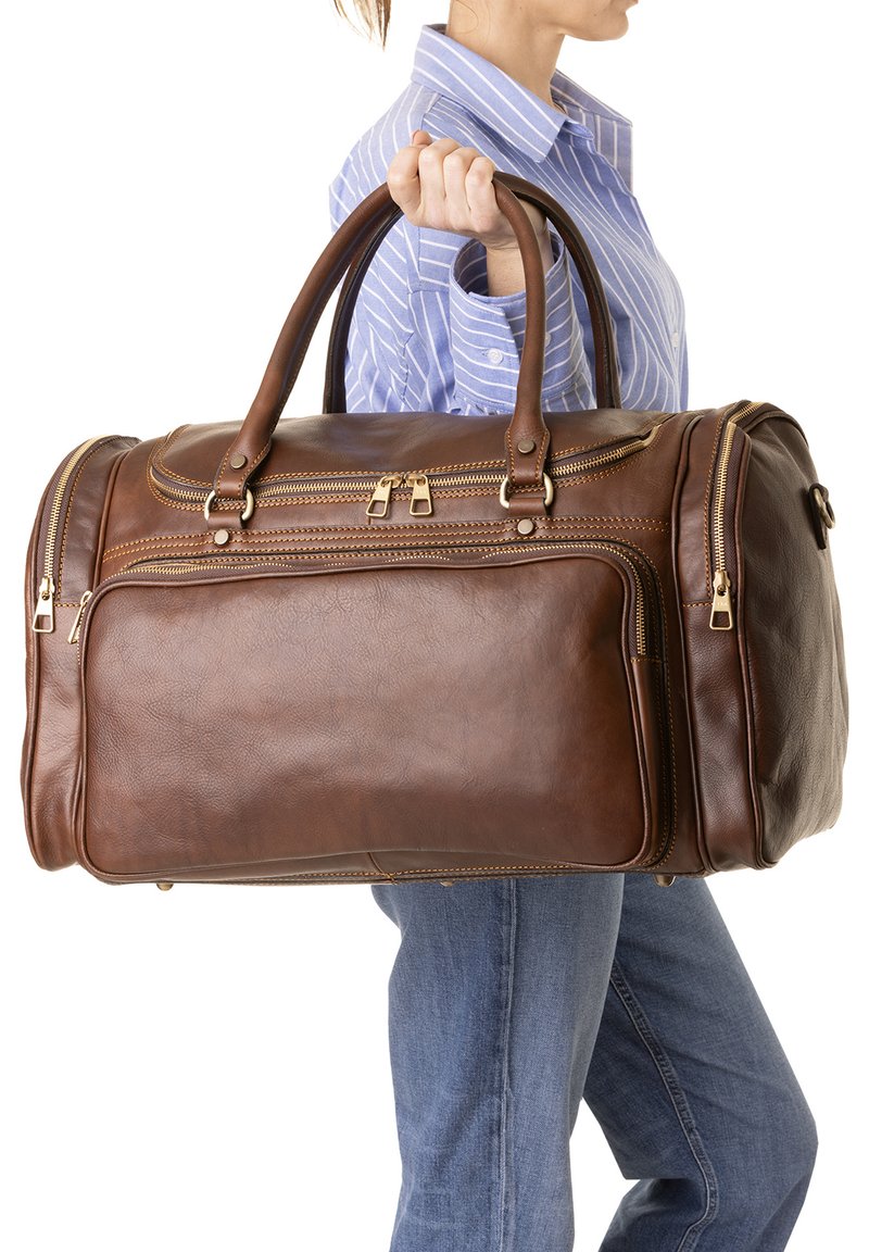 Bruine leren duffelbag met dubbele bovenhandvatten, gouden ritsen en meerdere compartimenten. Heeft een gestructureerde oppervlakte en een ronde vorm.