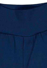 Marineblauwe leggings met een geribbelde tailleband en een soepele textuur. Heeft verticale naden voor structuur. Materiaal lijkt rekbaar te zijn.