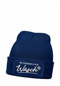 Knitted blue beanie with a folded cuff, featuring a white embroidered patch with text and a flower graphic. Text reads "MEI LEDERHOSN IS IN DA WÄSCH."