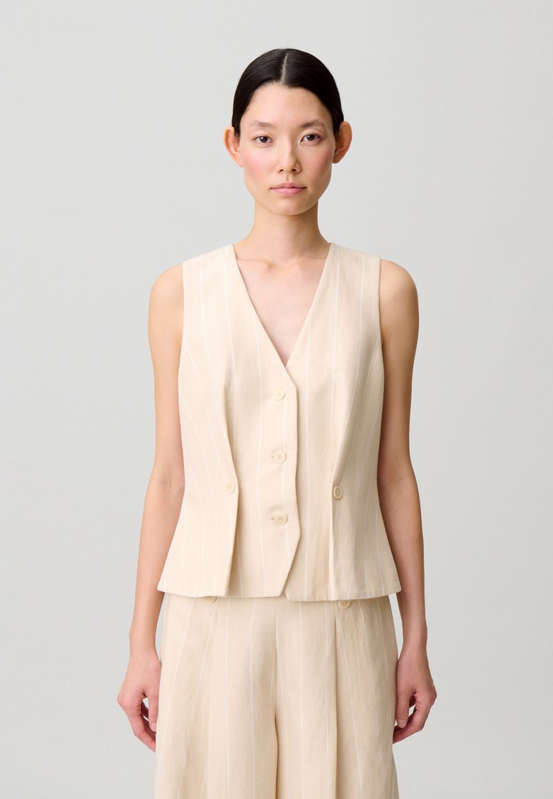 Gilet senza maniche color crema con scollo a V, due bottoni frontali e strisce verticali bianche, realizzato in tessuto leggero.