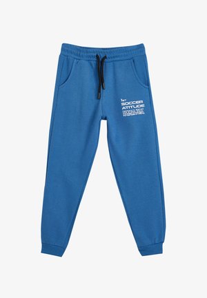 Pantalones de chándal azules hechos de una tela suave, con una cinturilla elástica y cordón ajustable, bolsillos laterales y texto impreso en blanco en la parte delantera.