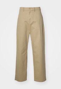Beige, wijde broekspijpen van een lichtgewicht stof. Bevat voorzakken, een knoopsluiting en een soepele textuur over het geheel.
