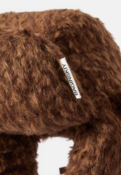 Giocattolo di peluche marrone con una finitura in pelliccia stropicciata e shaggy. Presenta un'etichetta con la scritta "BAGINSKY". Forma morbida e arrotondata.