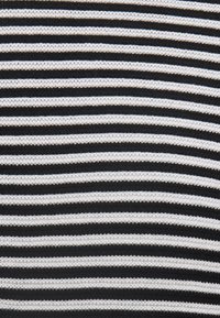 Randig tyg med växelvis horisontella svarta och vita linjer, tillverkat av ett strukturerat stickat material, med jämn mönsterfördelning.