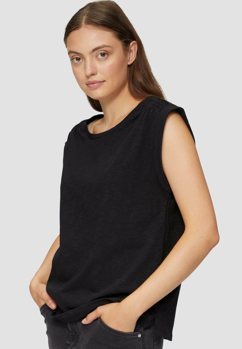 Zwarte mouwloze top met een relaxed fit, ronde halslijn en gestikte schouderdetails, gemaakt van zacht, textuurstof.