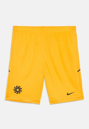 Bright yellow athletic shorts with black Nike swoosh and circular spiral logo near hem, featuring elastic waistband and mesh side panels.