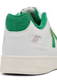 Weißer Sneaker mit grünem Wildleder-Fersen- und Kragenbereich, gefalteter Stofflasche, grünem Streifen an der Seite und dem Schriftzug „ST. POWER PLAY“ am Sohlenrand.